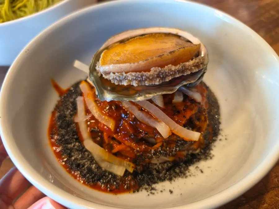 Mixing the abalone jang bibim naengmyeon with its sauce