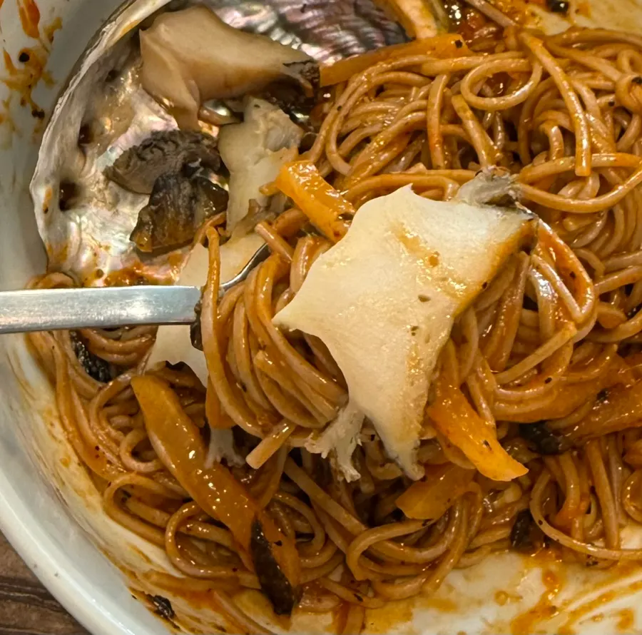 Sliced abalone and noodle strands from the bibim naengmyeon