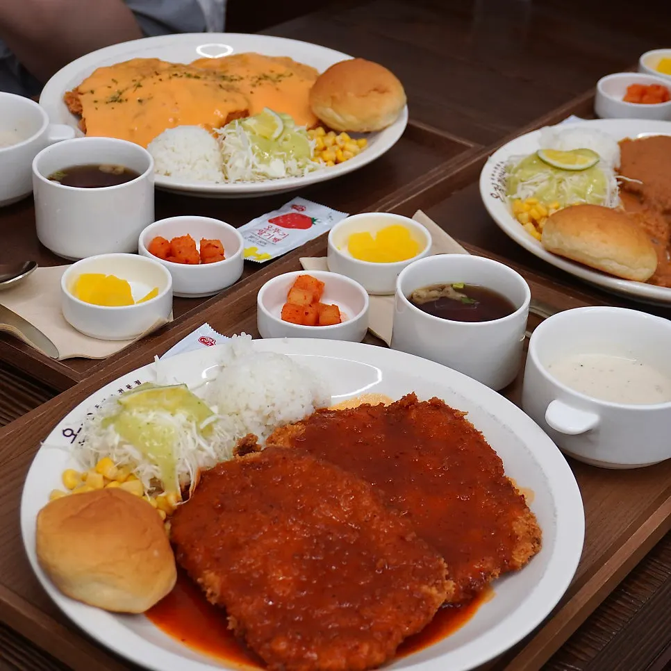 Table set with three plates of pork cutlet