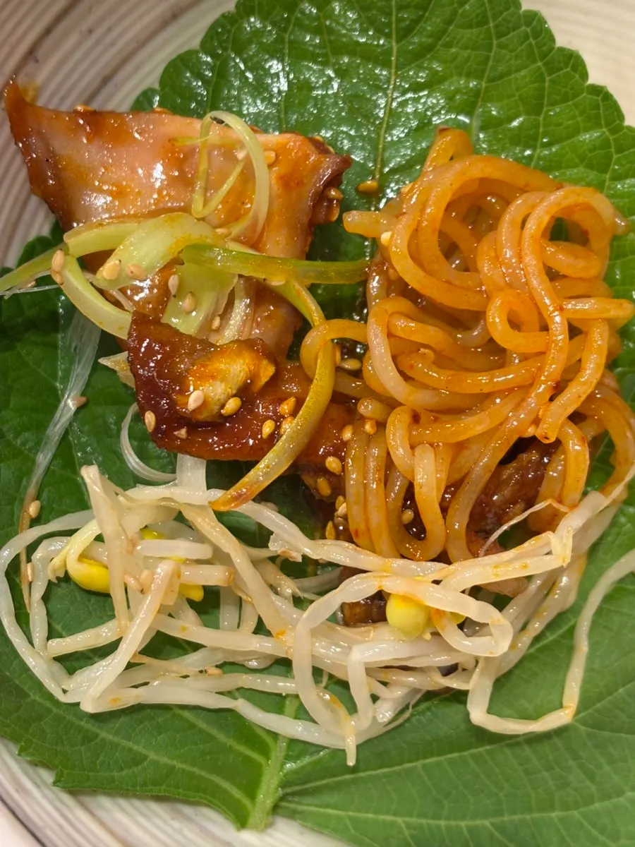 A wrap of pork and squid on a perilla leaf