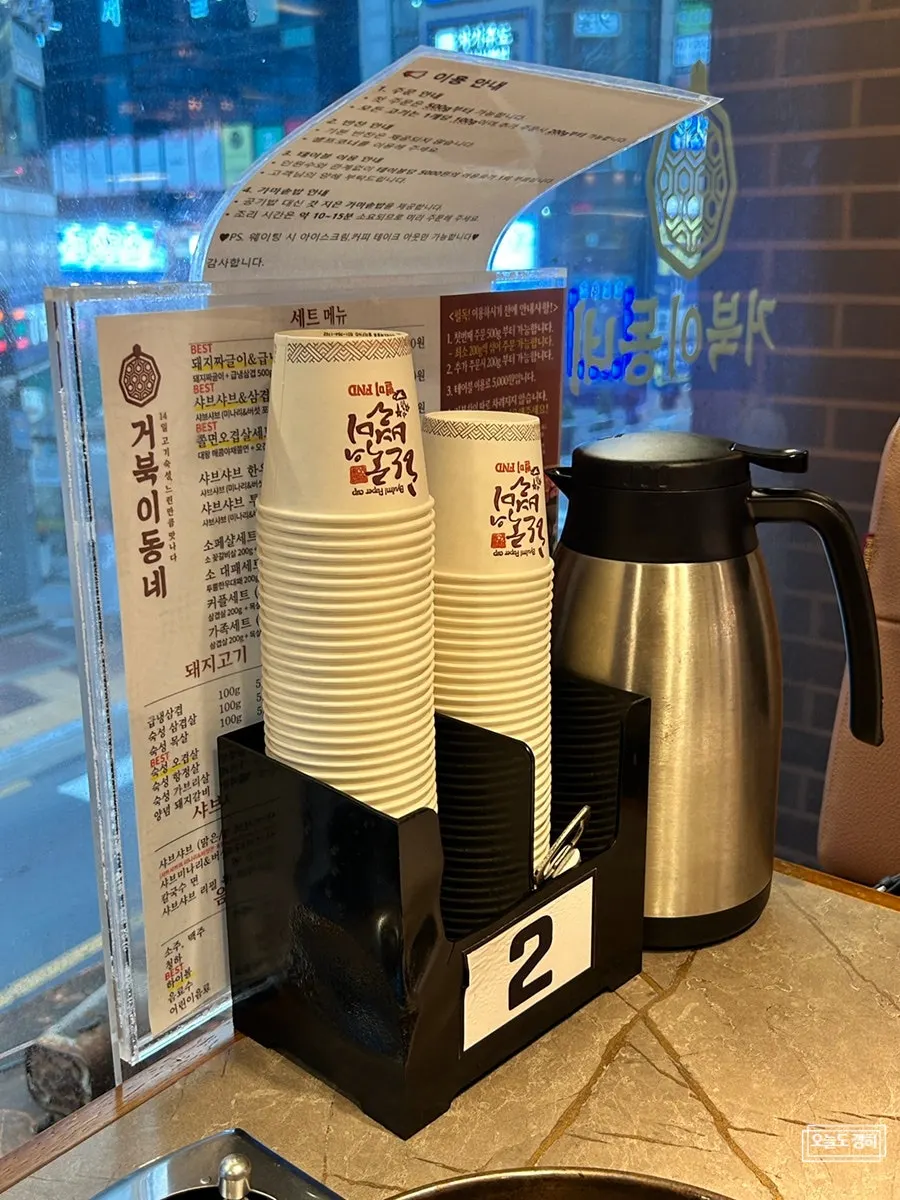 Menu, paper cups, and instructions on the table