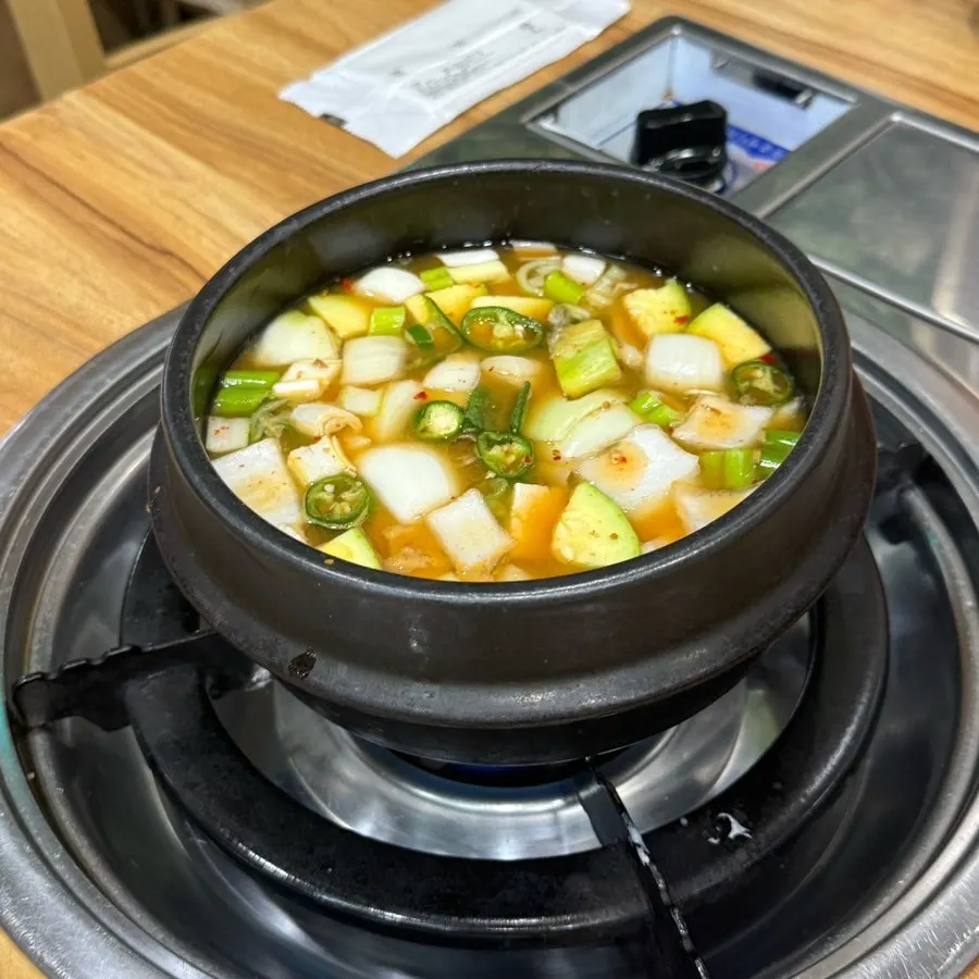 Doenjang jjigae simmering on the burner at the table
