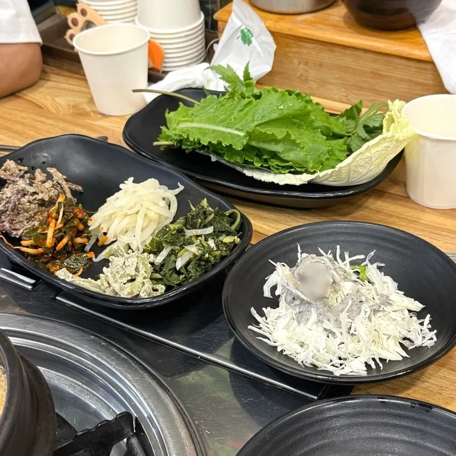 Hanjeongsik side dishes being set on the table