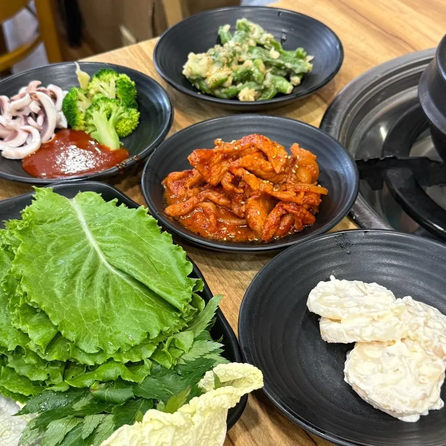Table spread with ssam vegetables and jeyuk-bokkeum