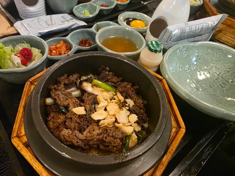 Close-up of green onion brisket pot rice topped with garlic slices