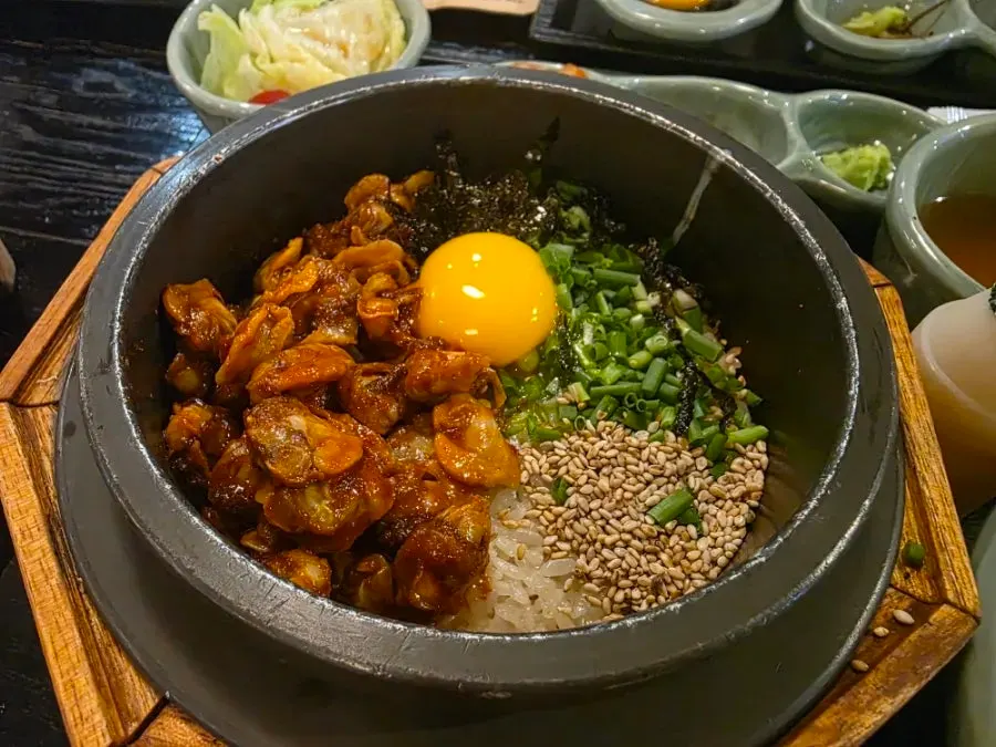 Cockle pot rice topped with an egg yolk