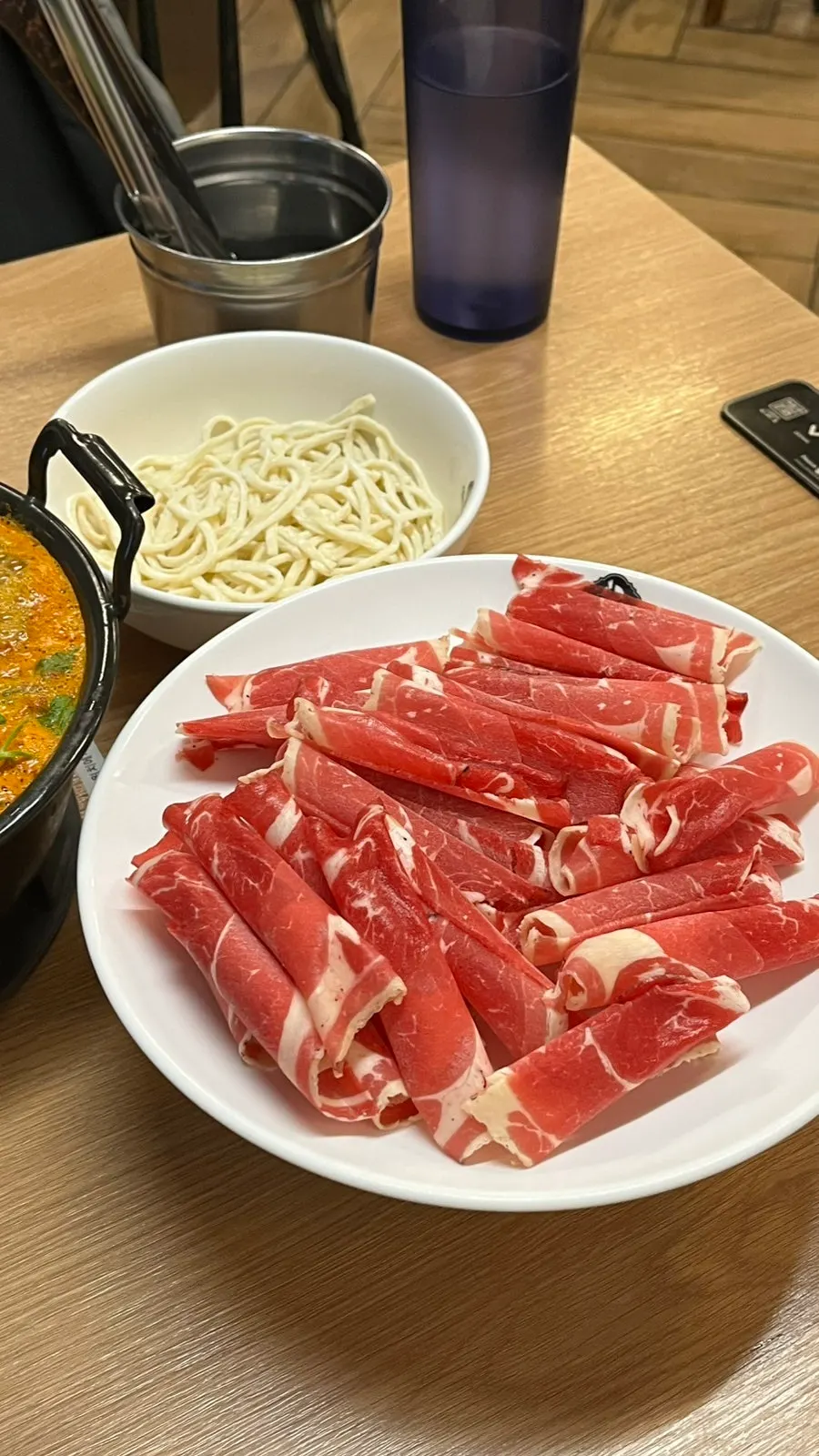 Table setting with spicy broth and added beef for shabu