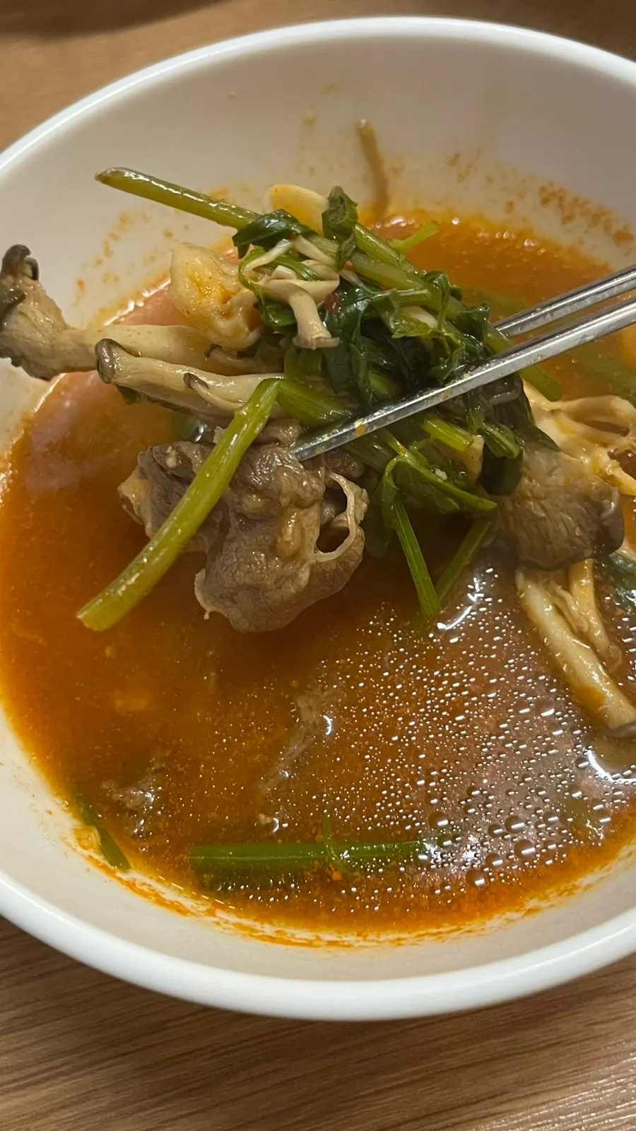 Spicy shabu broth with minari and mushrooms mixed together