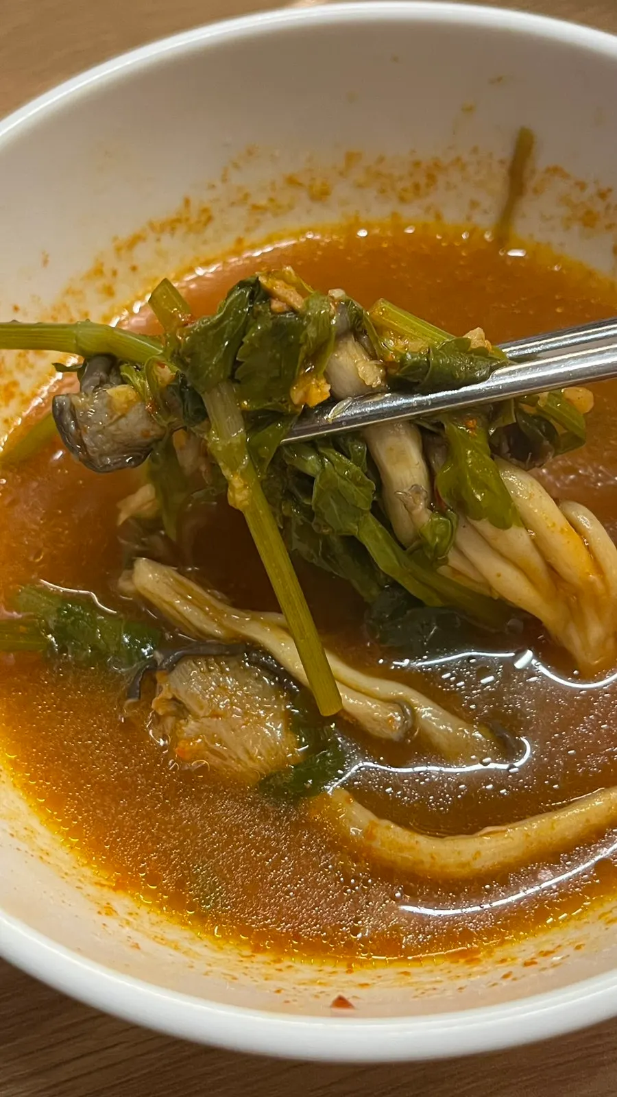 A bite-sized portion of minari, mushroom, and beef held together