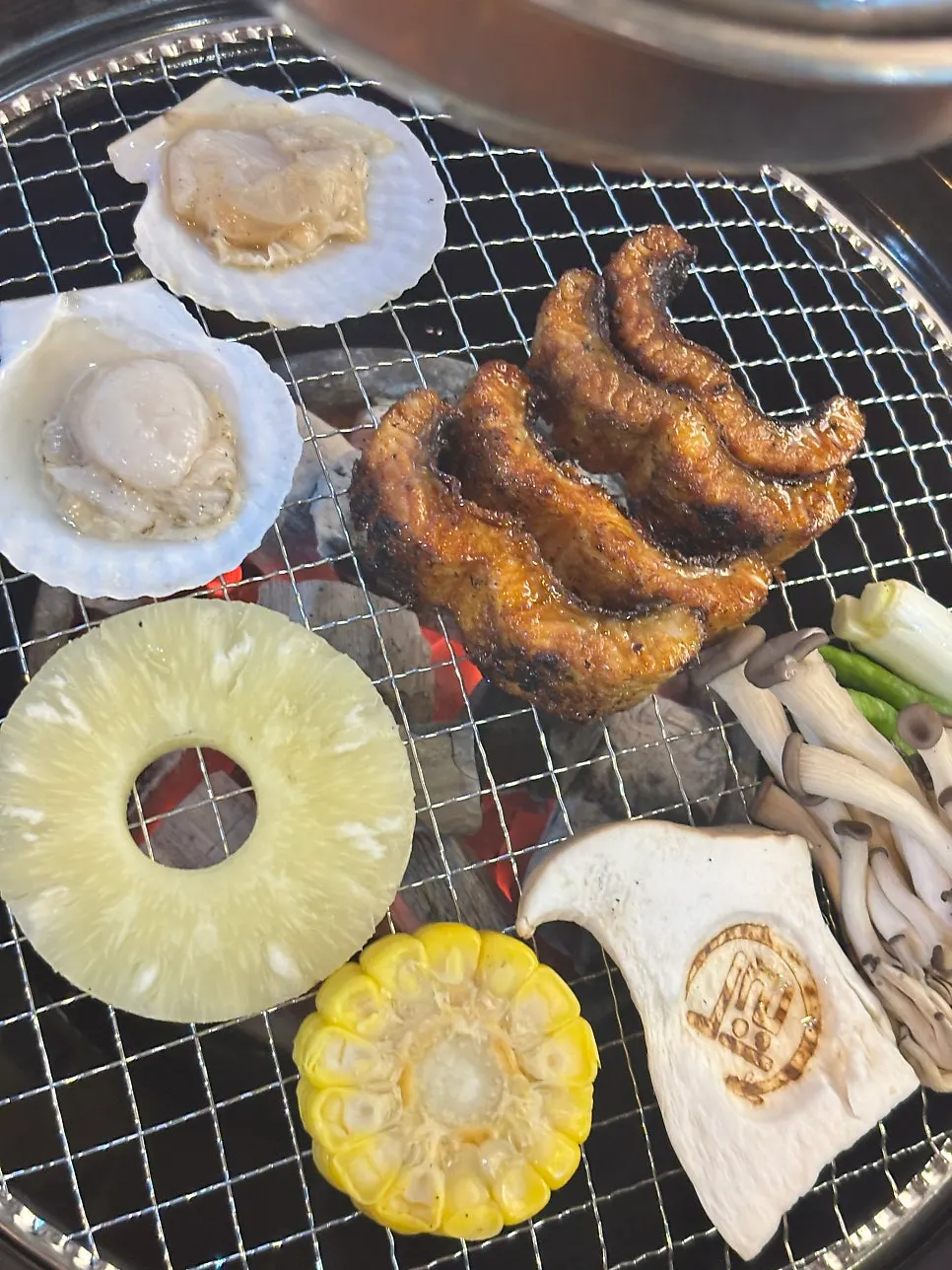 Eel and side vegetables cooking on the grill