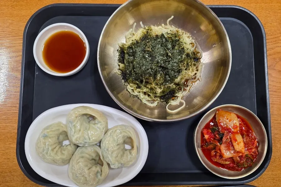 Deulgireum milmyeon dumpling set topped with seaweed flakes and sesame seeds