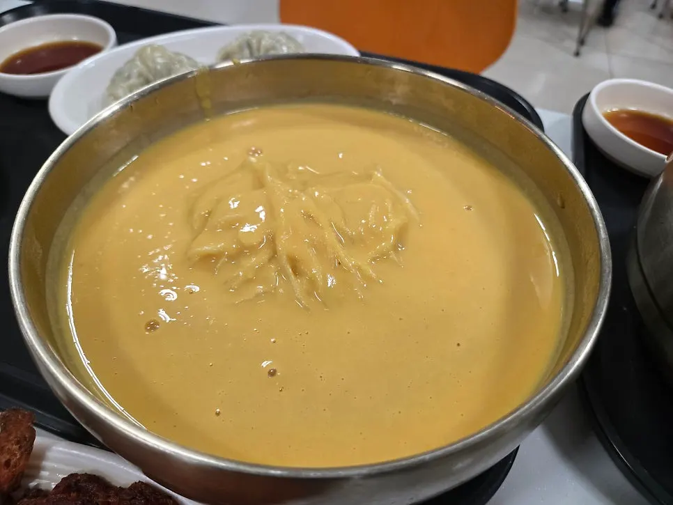 A bowl of pumpkin kongguksu with yellow broth