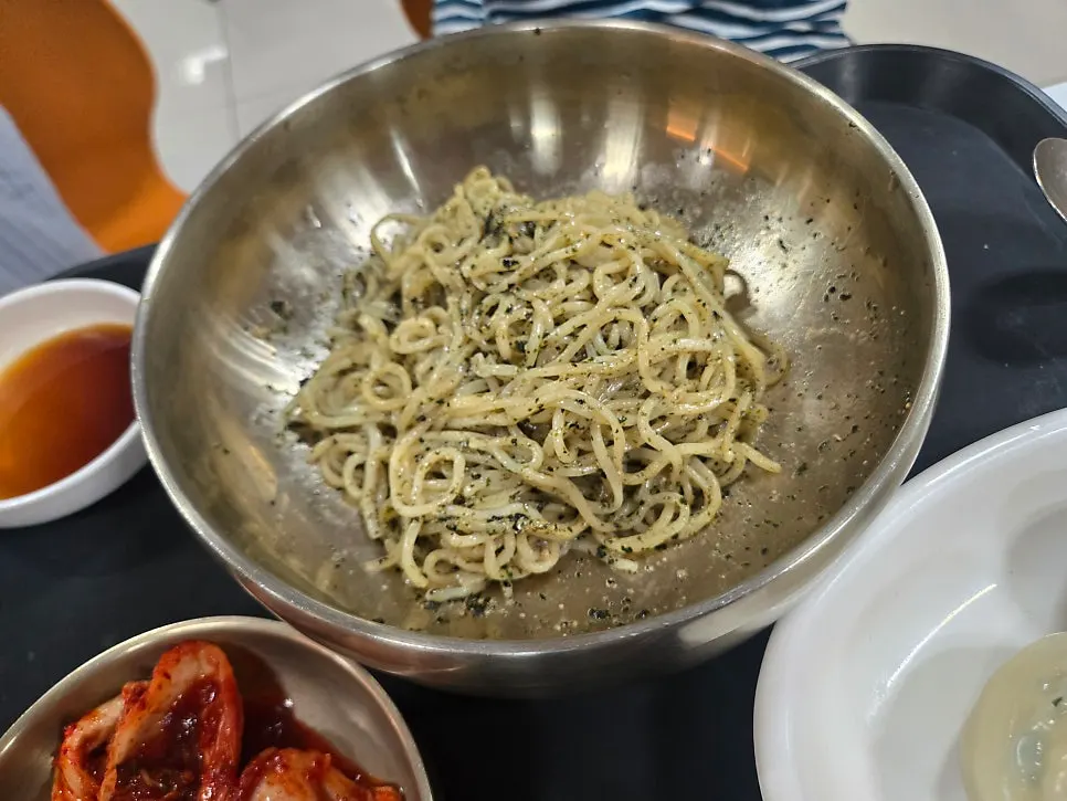 Noodles of the perilla oil milmyeon lifted up with chopsticks