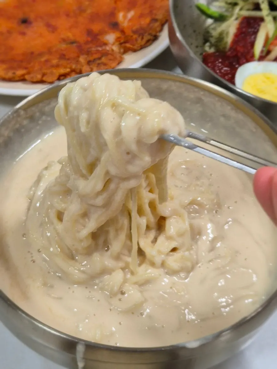 Noodle strands coated in nutty soy broth