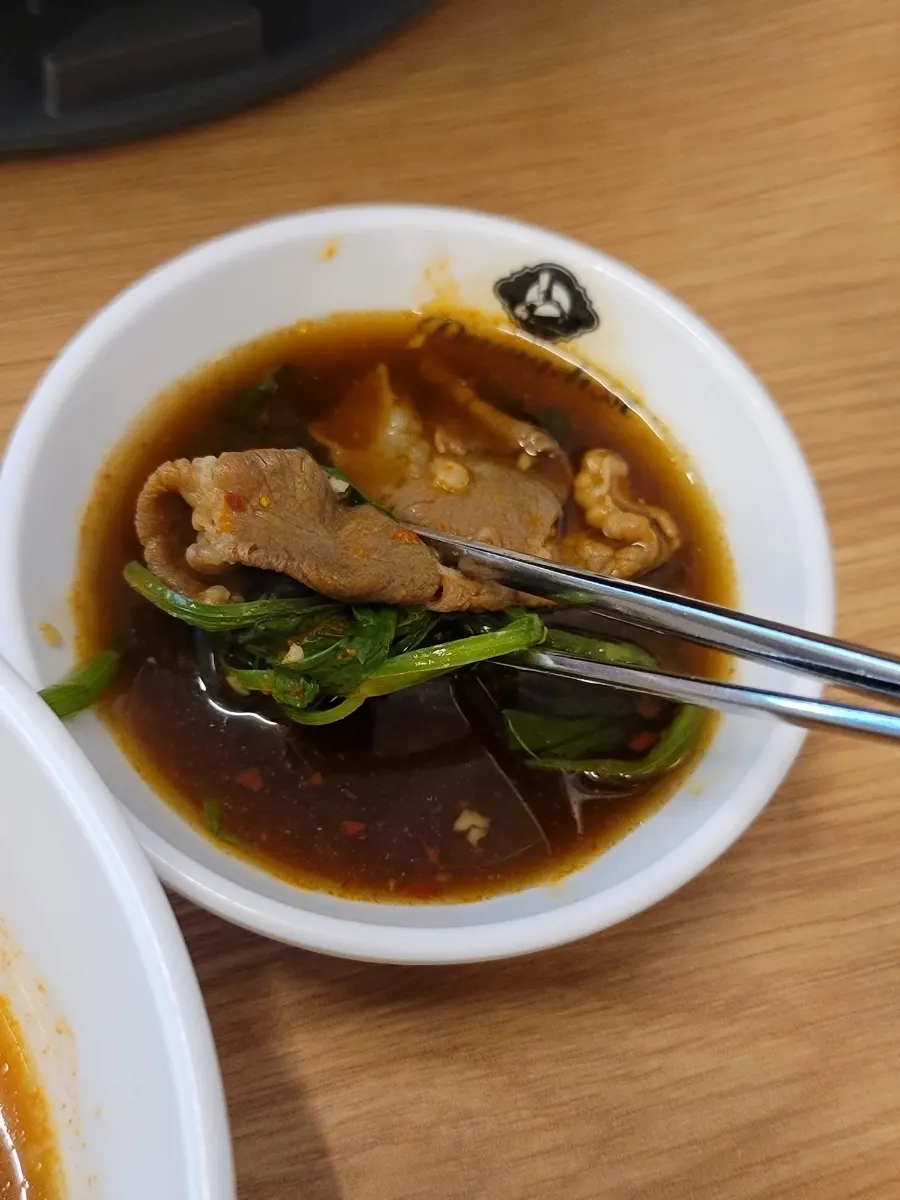 Minari and beef lifted together out of the pot