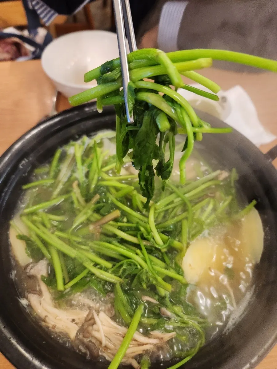 Minari and potato boiling in clear broth
