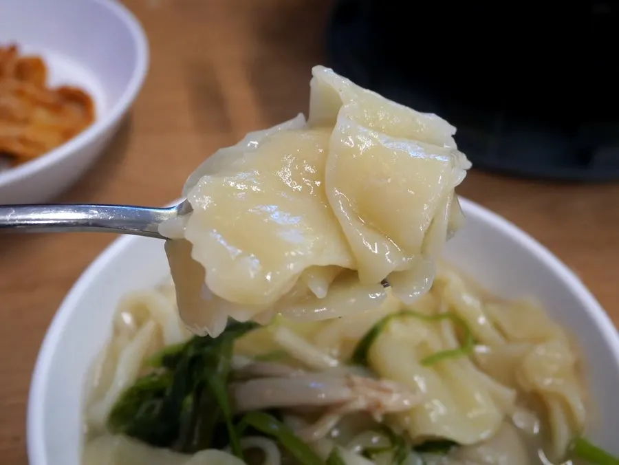Cooked vegetables being scooped out of the shabu-shabu