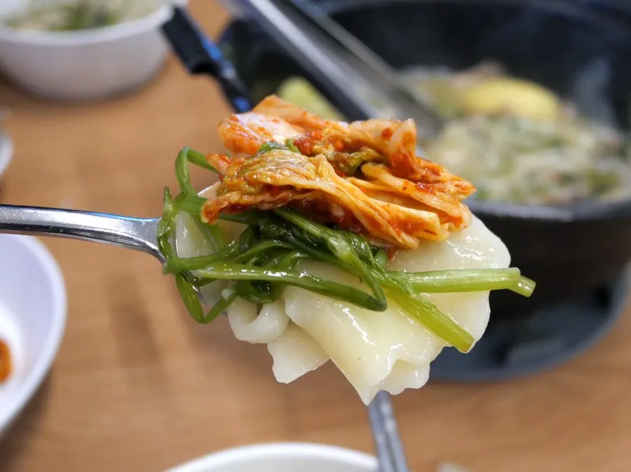 Pot with kalguksu, potato mandu, and sujebi sarrie added