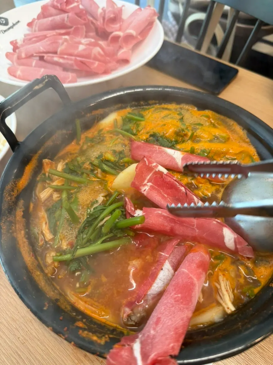 Meat being cooked in the boiling broth