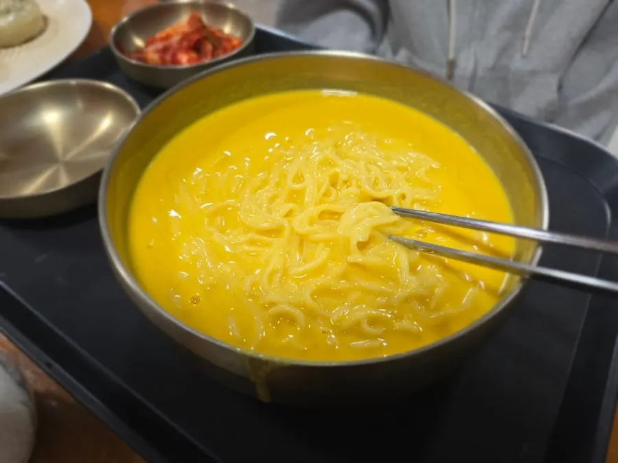 노란 콩국물이 담긴 단호박 콩국수 한 그릇