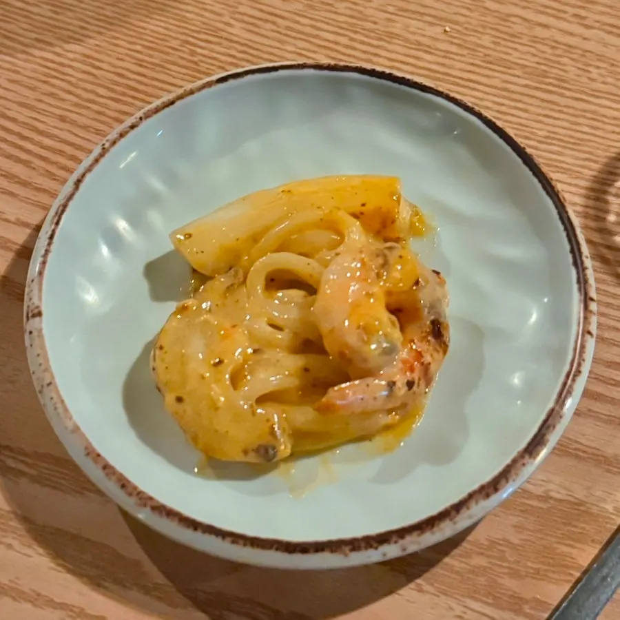 A bite of mala cream udon mixed with the egg yolk