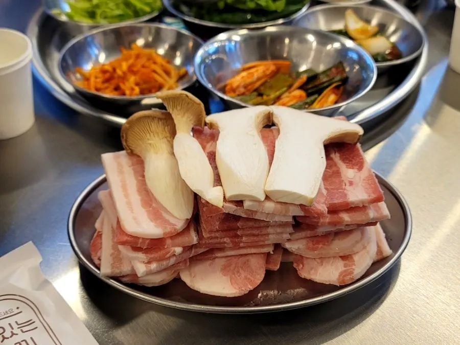 Basic table setting of kimchi and lettuce wraps beside the grill