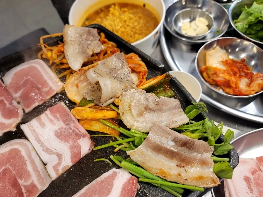 Cooked pork belly resting on top of kimchi