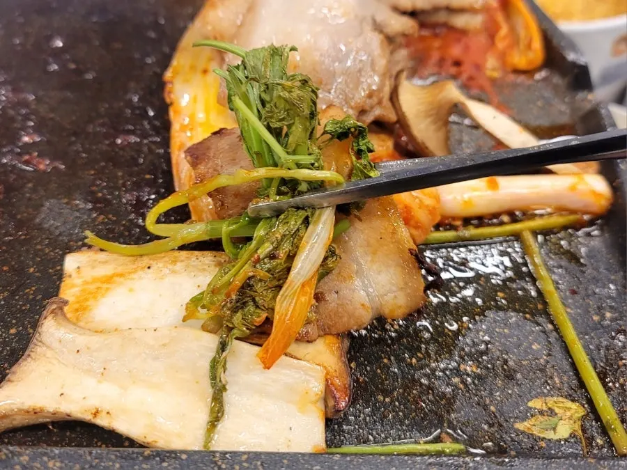 Grill topped with bean sprout salad and green onion kimchi from the self-service bar