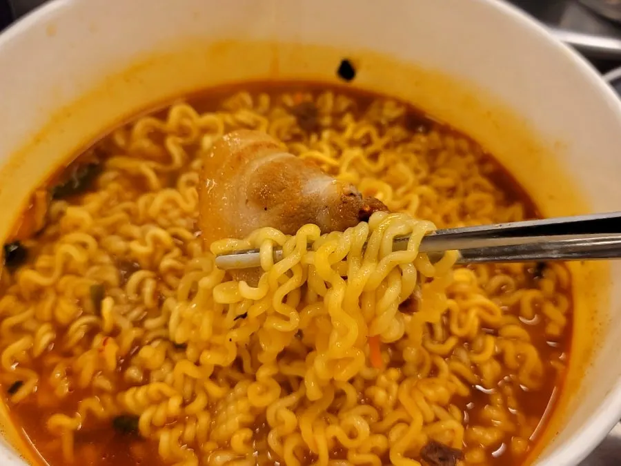 Lifting up a forkful of chewy ramyeon noodles