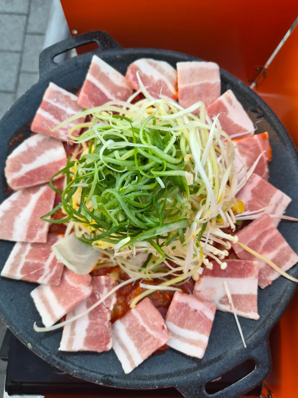 Jjuksam before cooking, with pork belly ringed around the edge