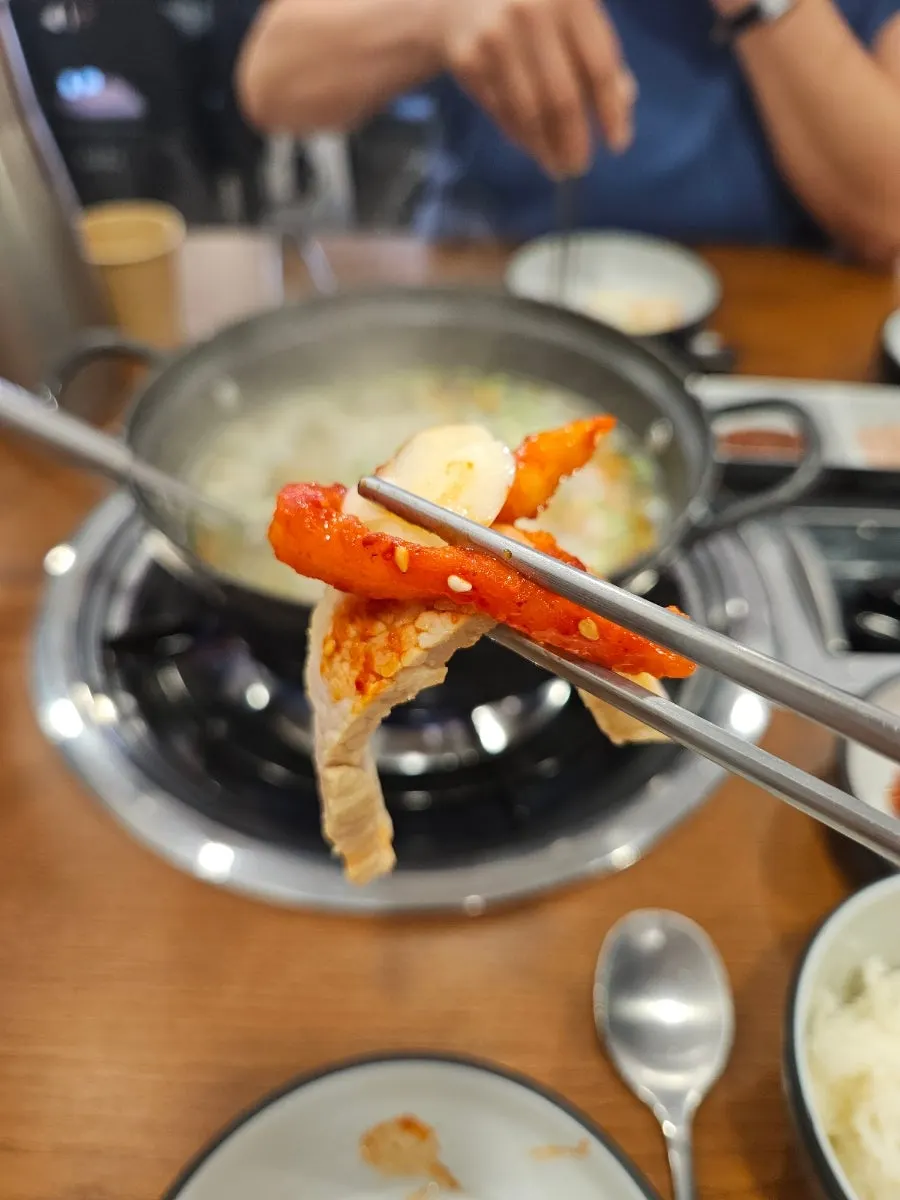 보쌈김치와 무생채를 곁들인 가브리살 수육 한 점
