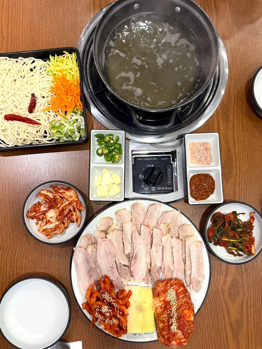 보쌈과 서비스 칼국수 냄비가 놓인 테이블