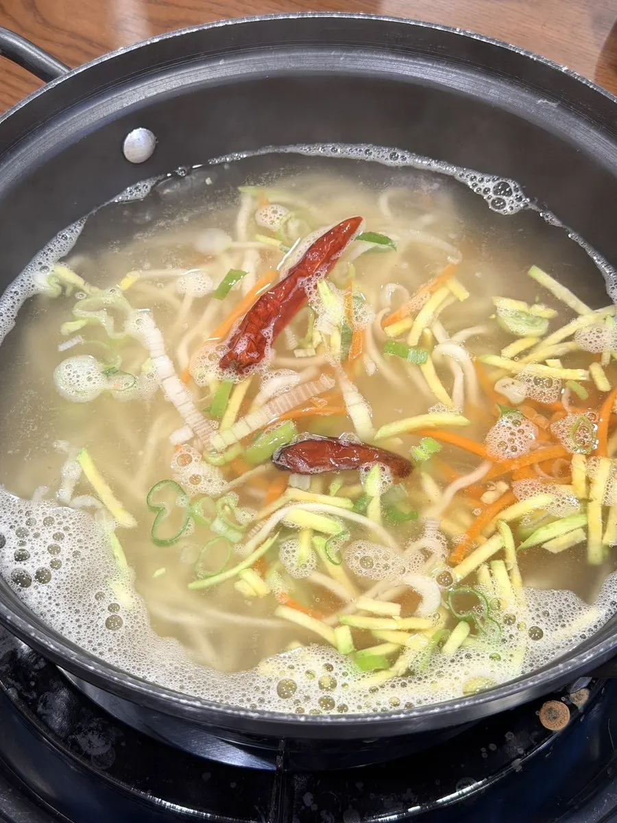 테이블에서 끓고 있는 서비스 칼국수