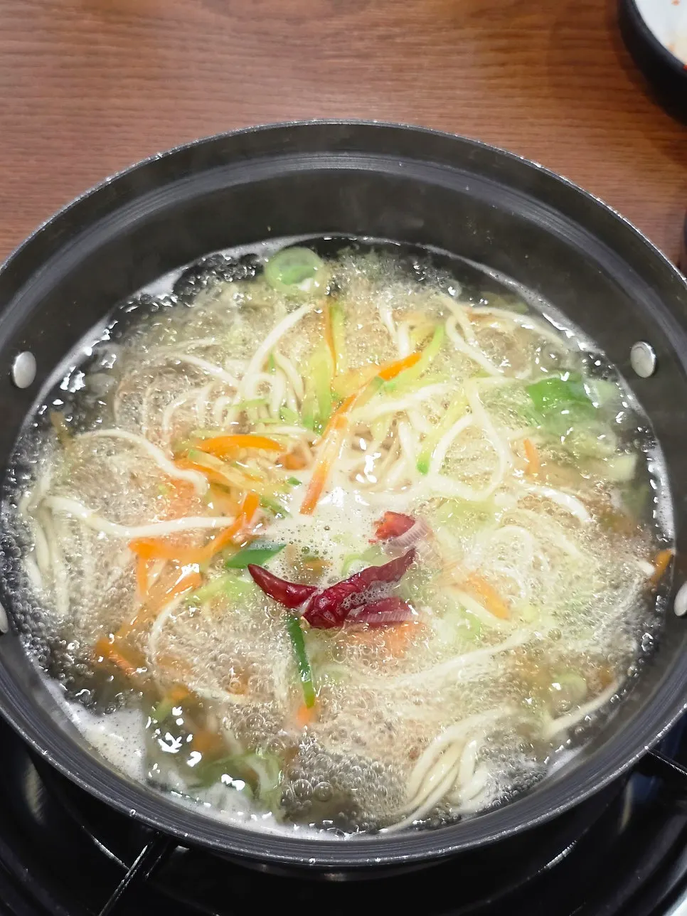 Kalguksu noodles being added into the boiling broth