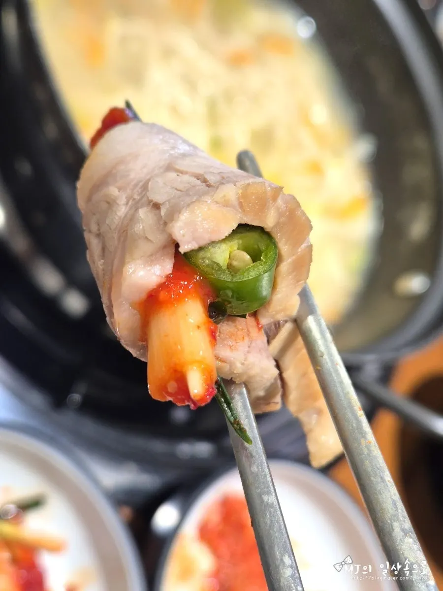 A piece of bossam topped with pa-kimchi