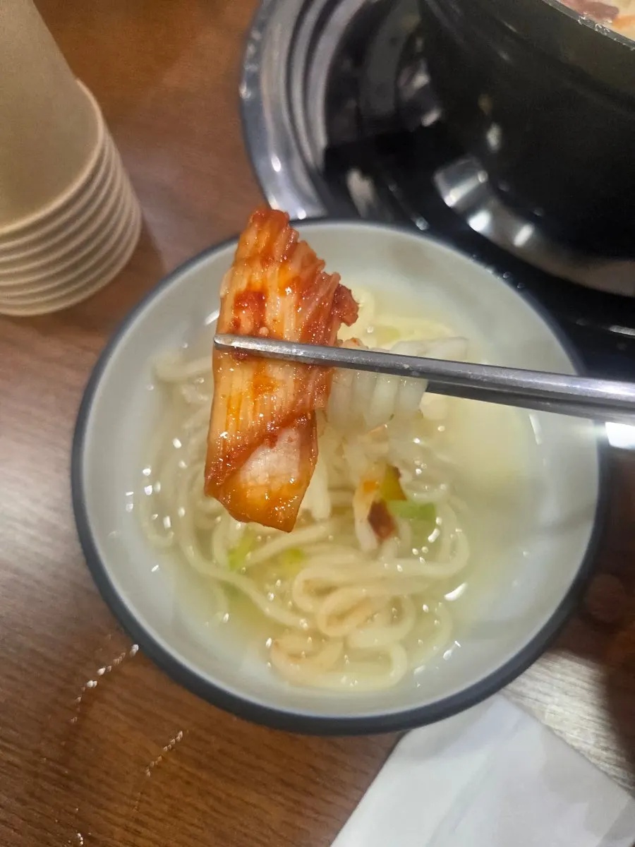 칼국수 국물에 적신 보쌈 고기