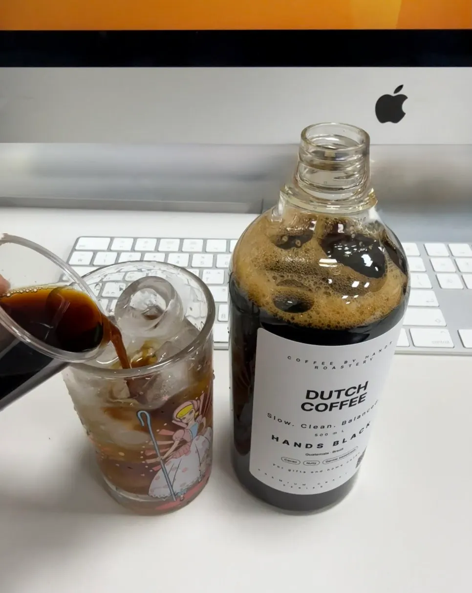 Cup with cold brew concentrate poured over ice water at the office