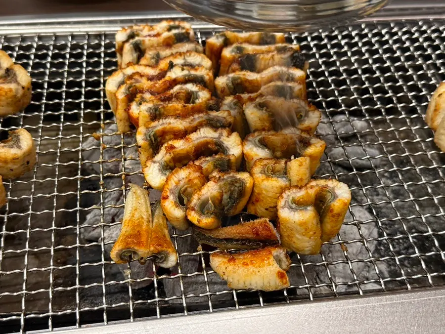 Gochujang-grilled eel cooking over charcoal