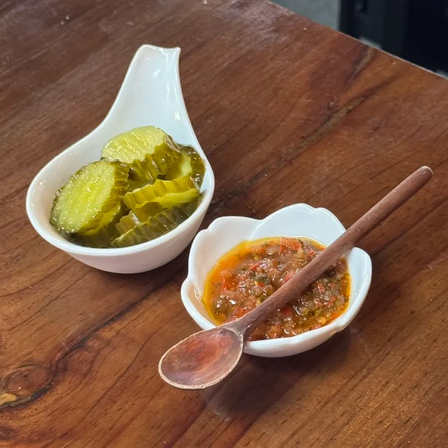 Pickles and handmade hot sauce served with pizza