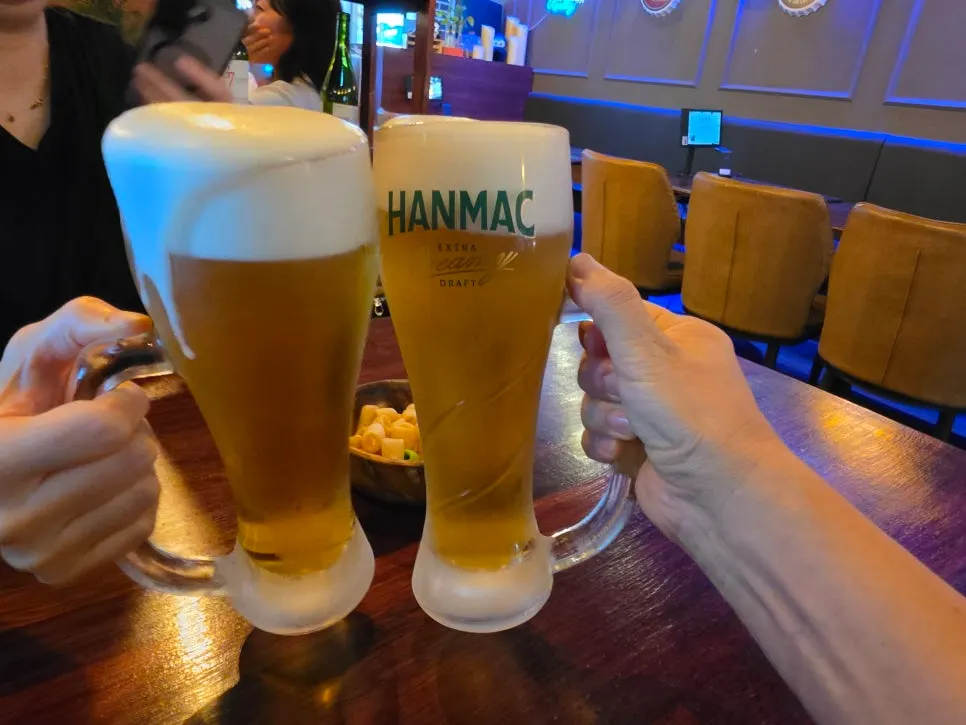 Cheersing with two glasses of cream draft beer