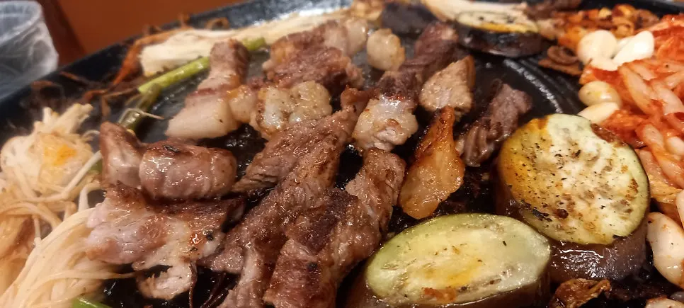 Enoki mushrooms and eggplant placed on the cauldron-lid grill