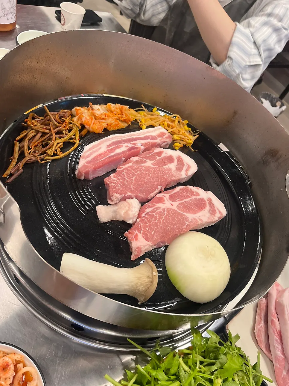 Cast-iron pot lid grill placed at the center of the table