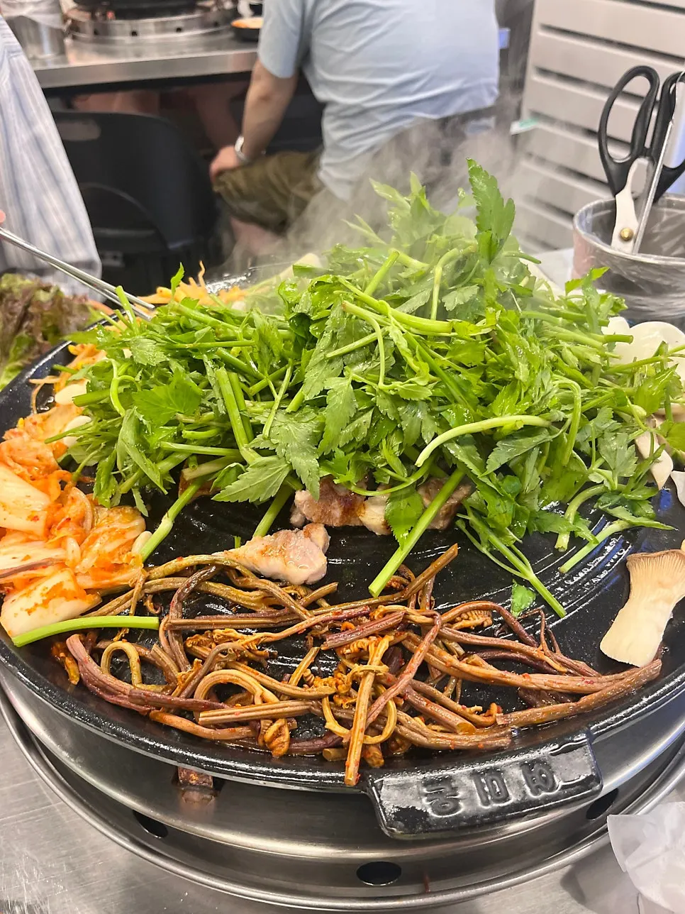 Cast-iron lid piled high with minari
