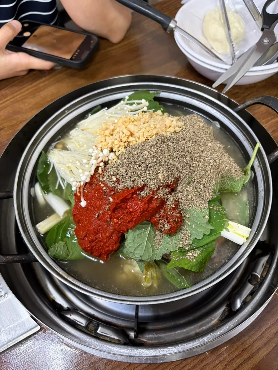 A pot of gamjatang generous with perilla seeds