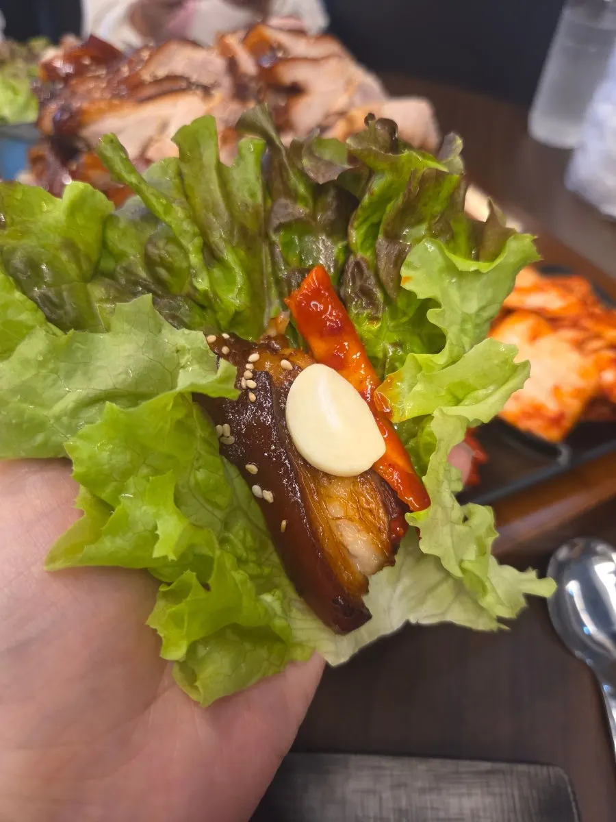 상추에 족발과 무말랭이를 올린 쌈 한 입