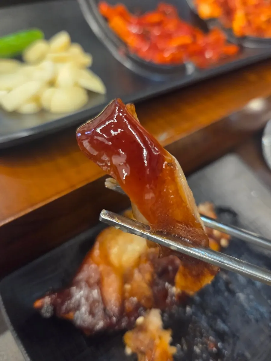 족발을 매운 소스에 찍는 모습