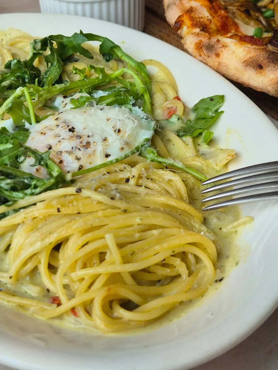 Cream pasta mixed with a poached egg