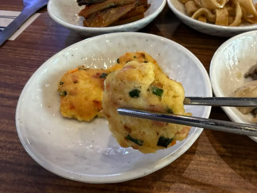 Plate of seasoned sweet potato stem and sautéed mushroom side dishes