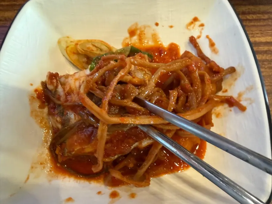 Sweet potato stems layered beneath the galchi jorim