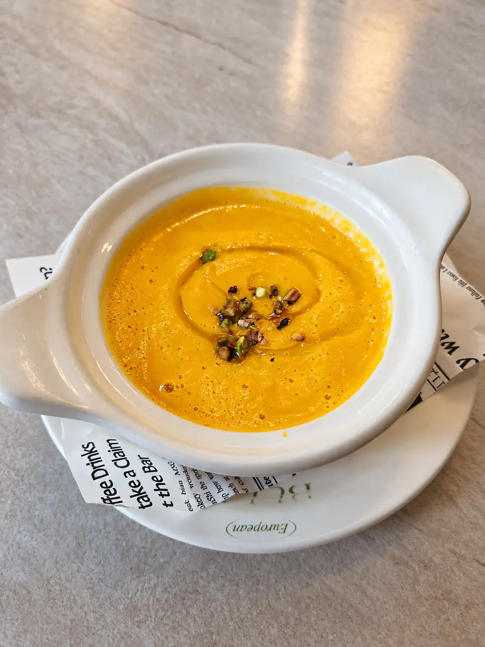 Sweet pumpkin soup topped with oil and nuts